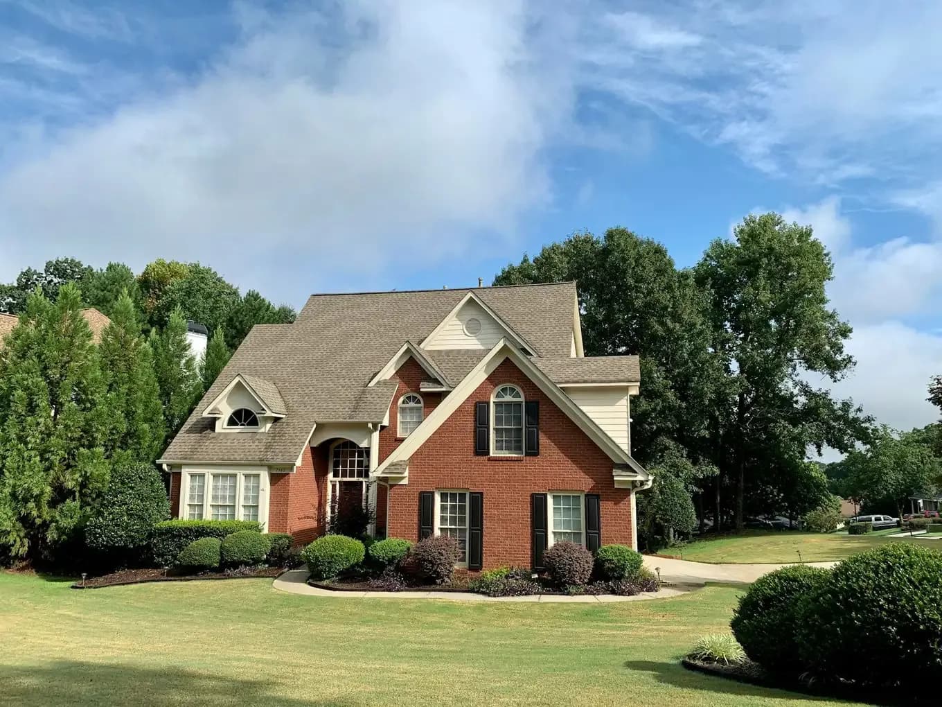 Brick family home exterior with a landscaped front yard